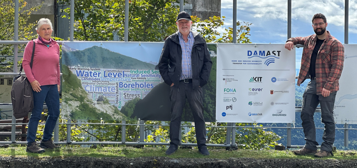 Bild auf dem Damm mit Banner und drei Personen